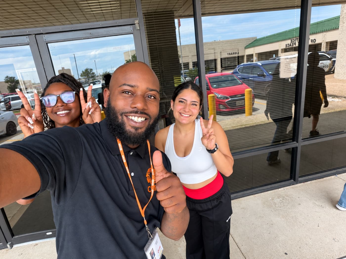 A fundraiser and two supporters flashing peace signs outside a storefront