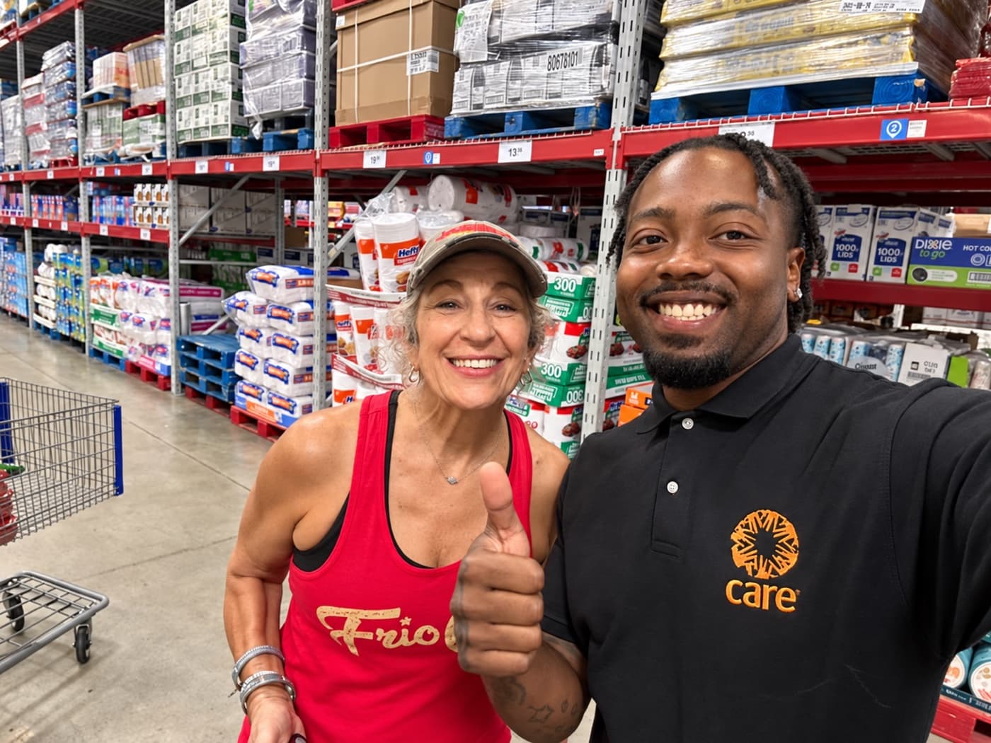 A fundraiser and a supporter giving thumbs up in a warehouse store aisle