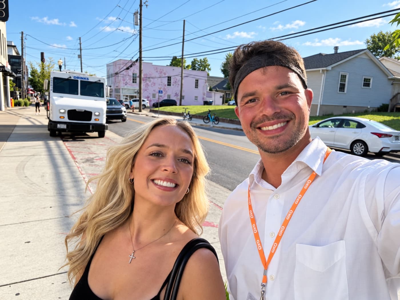A fundraiser and a supporter smiling on a sunny small-town sidewalk