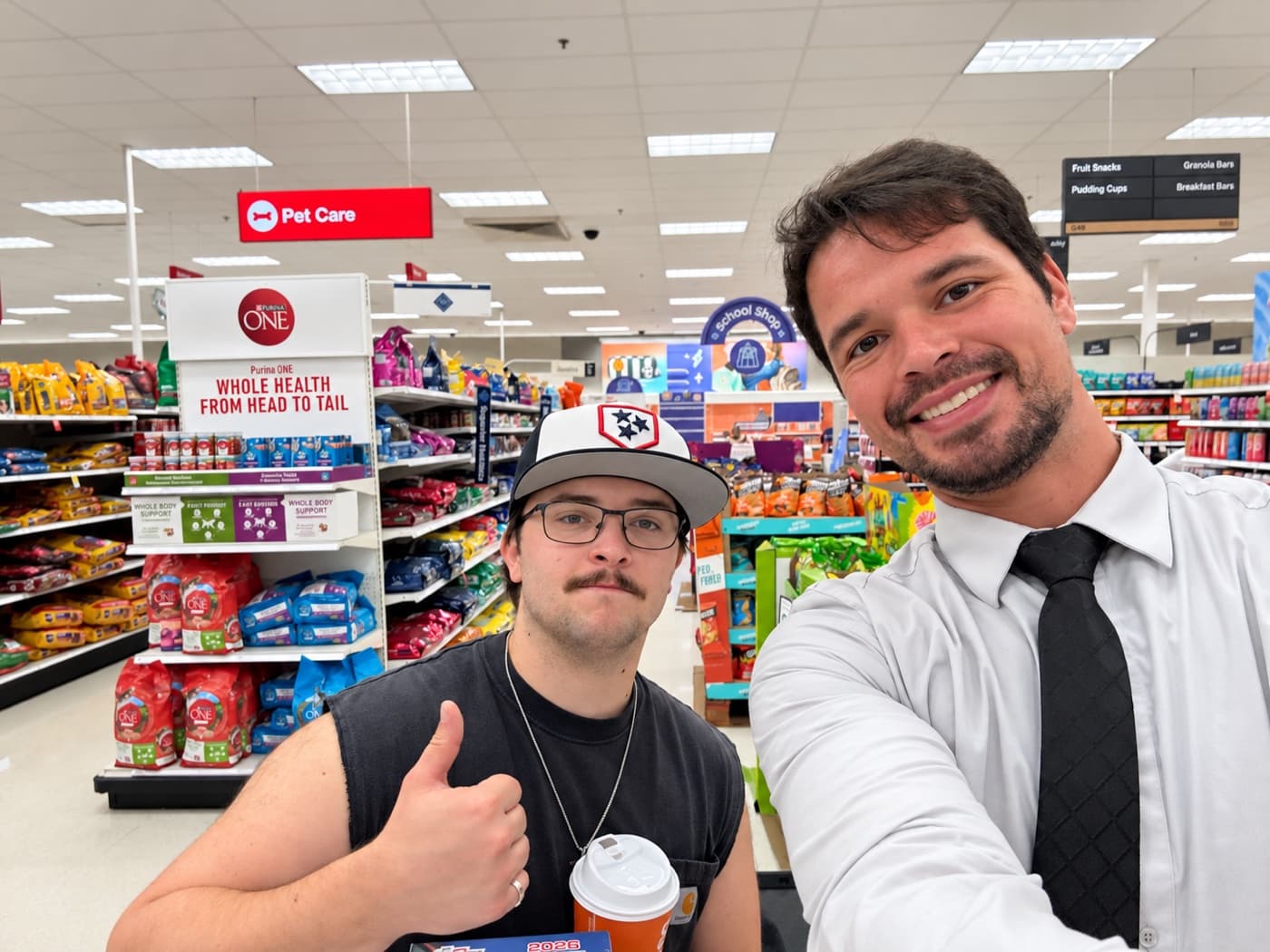 A fundraiser and a supporter giving a thumbs up in a store aisle